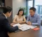 Family Asset Review A couple reviews financial and property documents with a divorce lawyer during a calm legal consultation in Singapore
