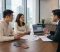 Travel Asset Discussion A couple discusses travel documents, credit cards, and frequent flyer miles with a divorce lawyer in a professional office