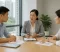 Property Settlement Discussion A divorce lawyer discusses property settlement matters with a couple using documents and a model house