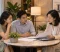 Divorce Legal Advice An Asian couple consults with a female legal professional who explains divorce-related paperwork and discusses legal arrangements during a meeting in Singapore
